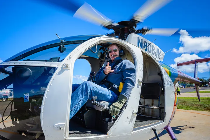 Photographer with professional camera on doors-off helicopter flight