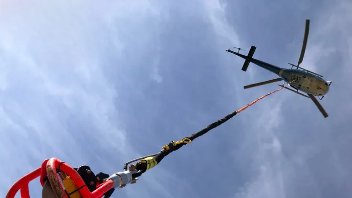Helicopter carrying external sling load cargo in remote area