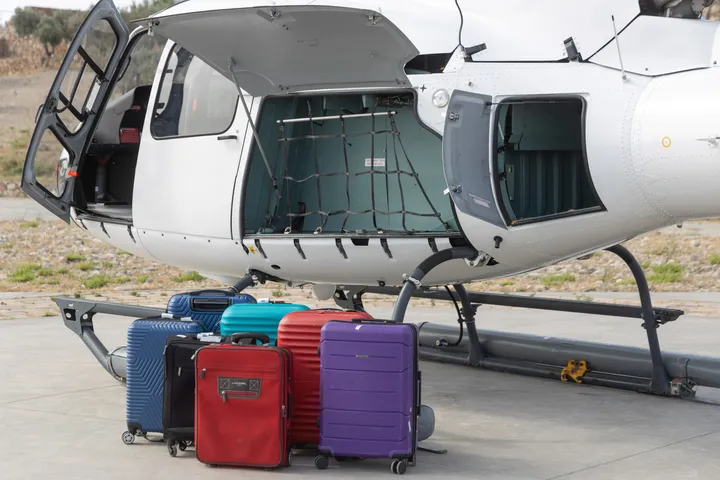 Soft duffel bags loaded into helicopter baggage compartment for flight